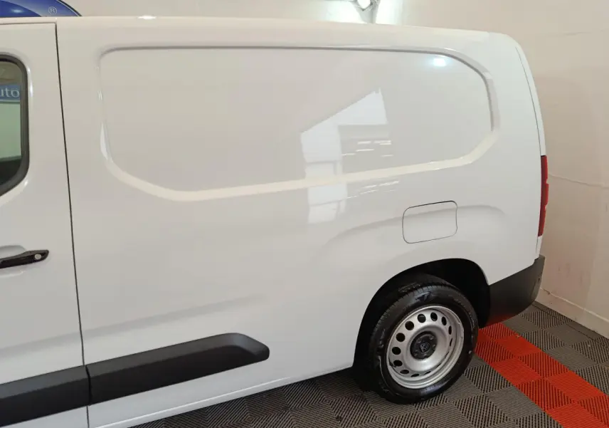 Vue latérale droite du Peugeot Partner blanc XL 950kg avec porte latérale pleine et jante acier simple.