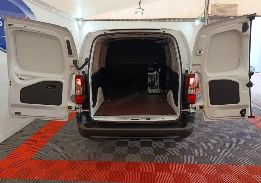 Vue arrière du Peugeot Partner XL blanc 2025 avec portes ouvertes et grand espace de chargement vide.