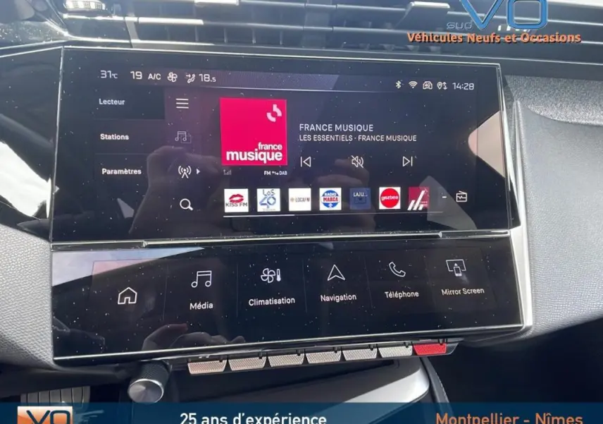 Vue rapprochée du tableau de bord tactile de la Peugeot 308 gris 2024, affichant l’interface multimédia France Musique.