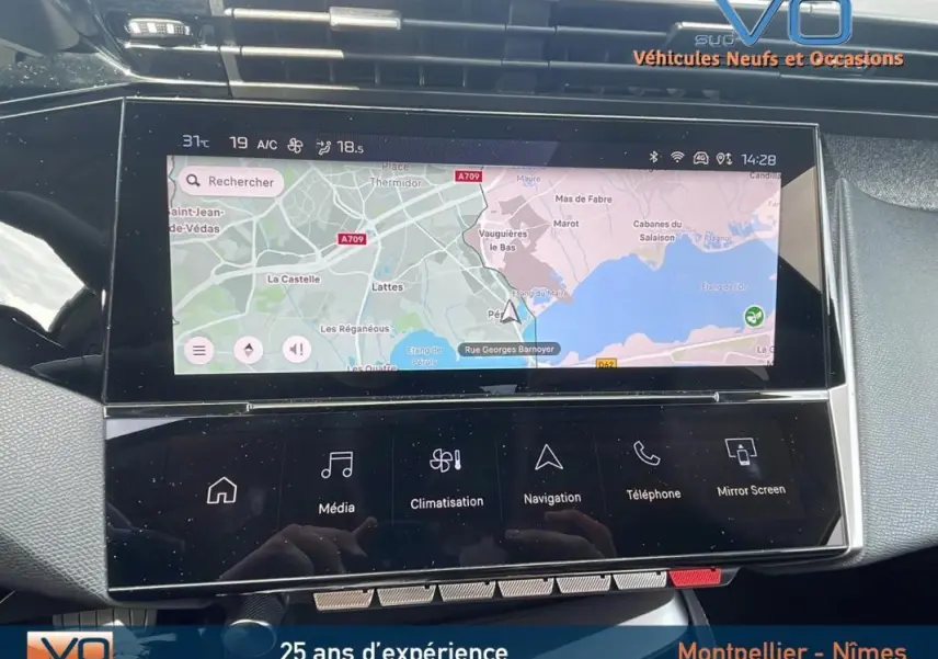 Vue rapprochée de l'écran tactile central du Peugeot 308 gris 2024, affichant la navigation GPS et commandes multimédia.