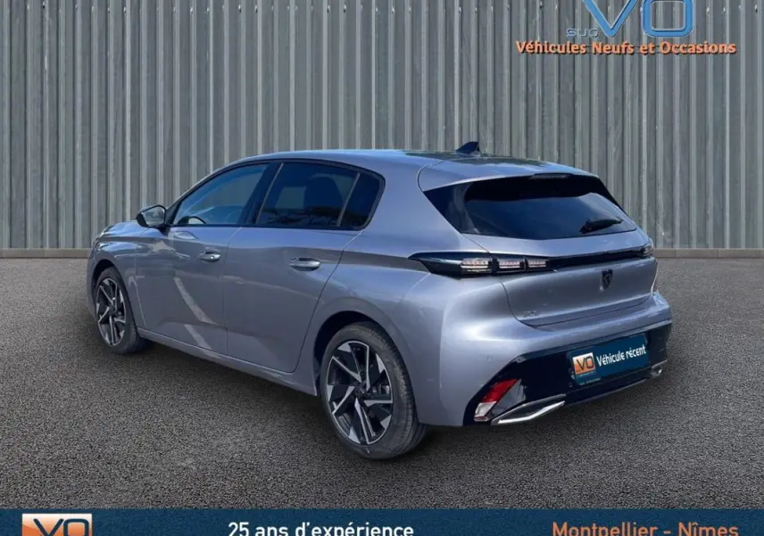 Vue 3/4 arrière droite d'une Peugeot 308 gris métallisé 2024, avec feux arrière LED et jantes alliage distinctives.