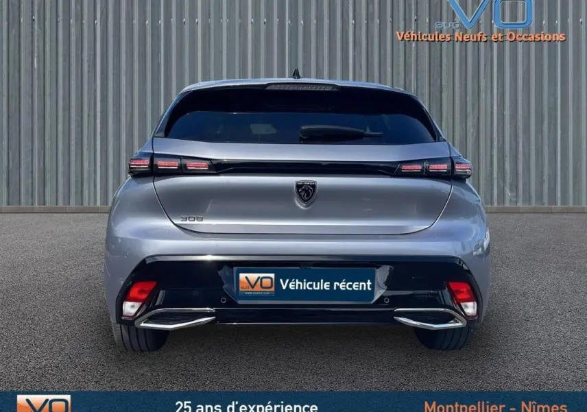 Vue arrière d'une Peugeot 308 gris métallisé 2024 avec feux LED et double sortie d'échappement chromée.