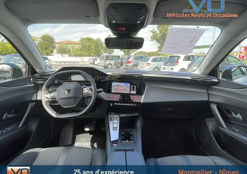 Vue intérieure avant de la Peugeot 308 gris 2024, avec volant compact, écran tactile et console centrale moderne.