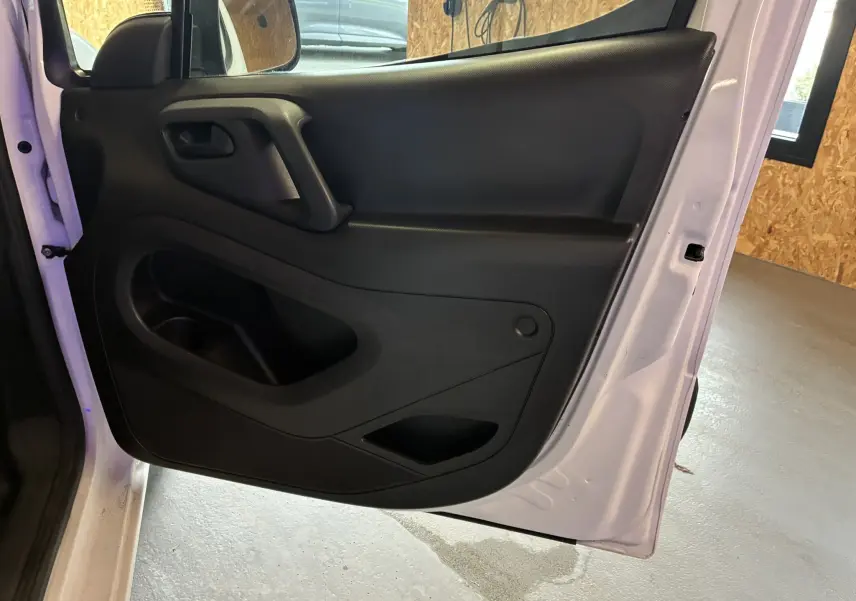 Vue rapprochée de la porte arrière gauche noire du Citroën Berlingo blanc 2016, mettant en valeur la poignée et les rangements intégrés.