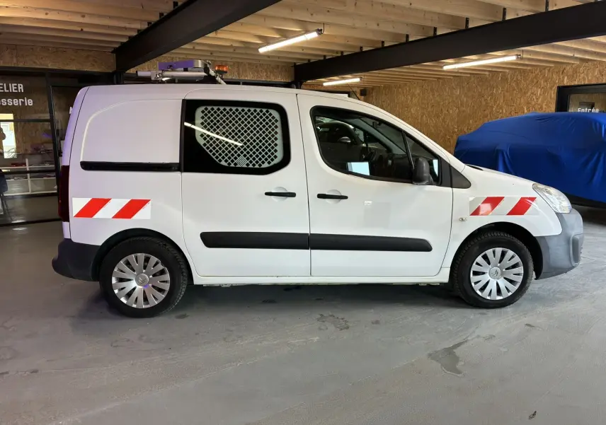 Vue de profil côté droit d'un Citroën Berlingo blanc 2016 avec marquages rouges et blancs réfléchissants sur les ailes avant et arrière.
