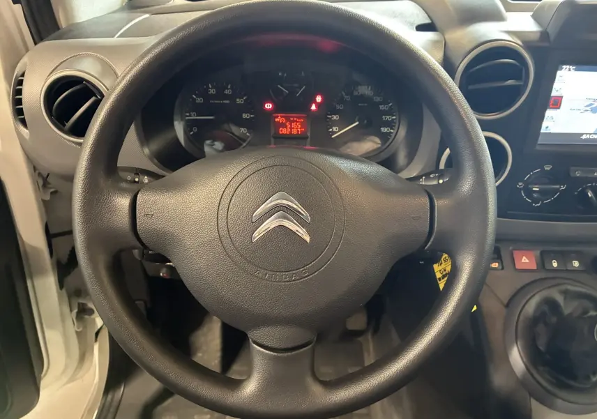 Vue rapprochée du volant noir de la Citroën Berlingo 1.6 BlueHDi 2016 avec tableau de bord et GPS visible à droite.