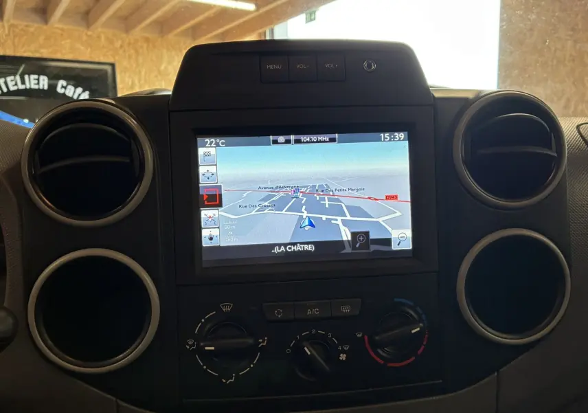 Vue rapprochée du tableau de bord noir du Citroën Berlingo 2016 avec écran GPS et commandes de climatisation.