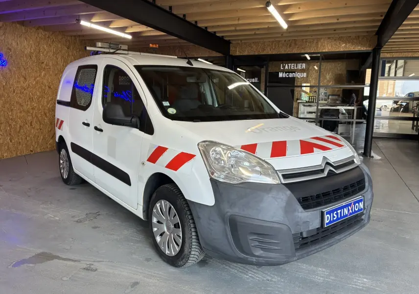 Vue 3/4 avant d'un Citroën Berlingo blanc de 2016 avec bandes rouges réfléchissantes et pare-chocs avant noir mat.