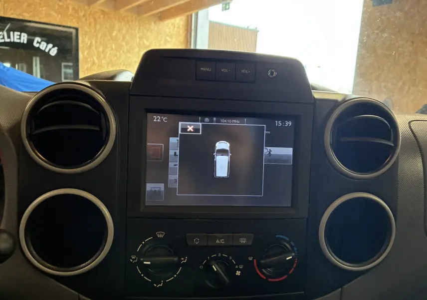 Vue rapprochée du tableau de bord noir du Citroën Berlingo 1.6 BlueHDi 100 avec écran central tactile et commandes climatisation.