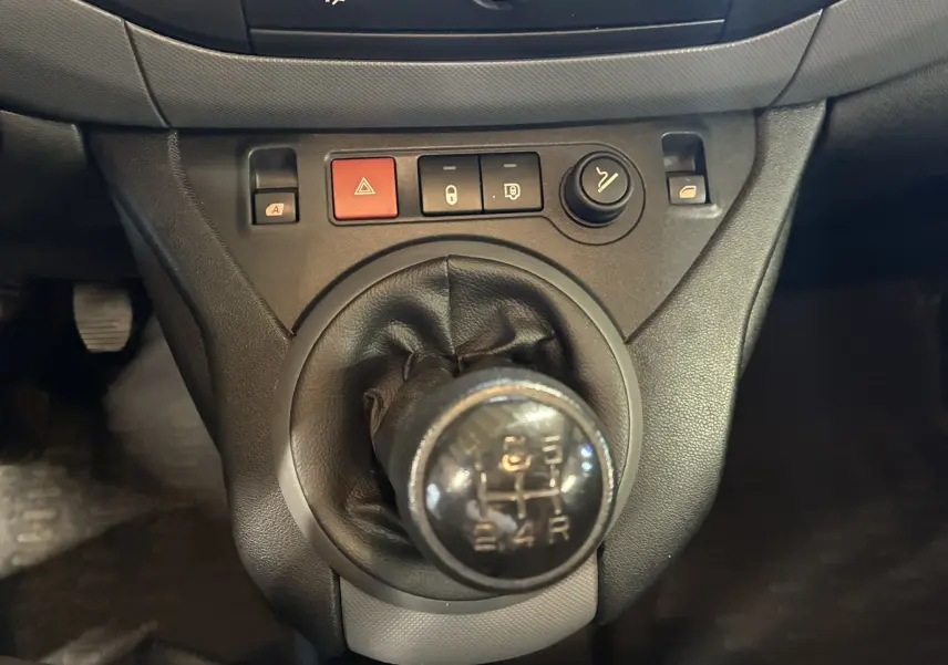 Gros plan sur le levier de vitesses manuel noir du Citroën Berlingo 1.6 BlueHDi 100 de 2016, avec boutons de commande autour.