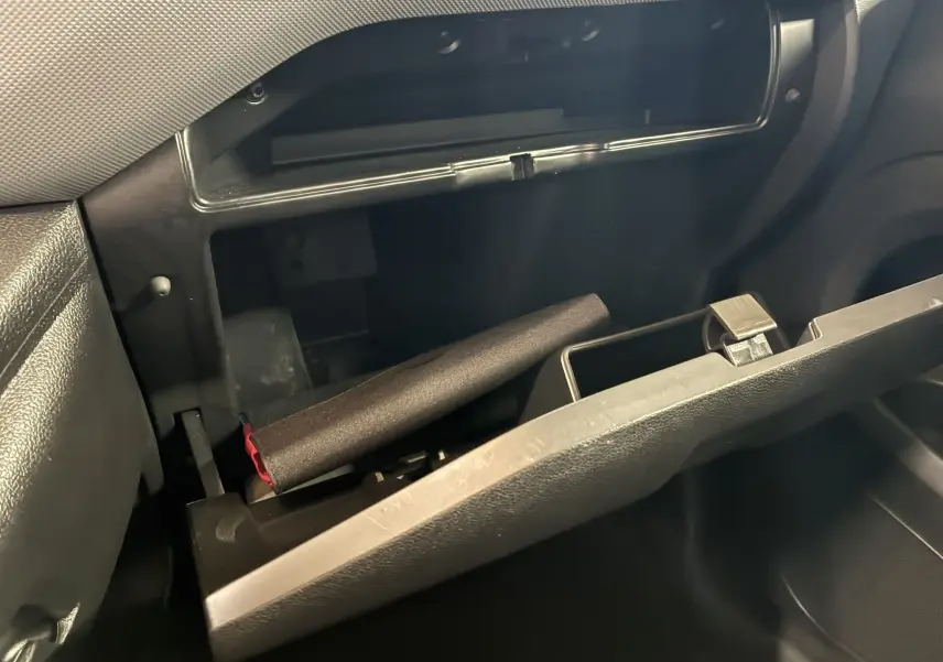 Vue intérieure du vide-poche côté passager ouvert du Citroën Berlingo blanc 2016, montrant un objet cylindrique noir à l'intérieur.