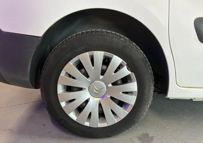 Gros plan sur la roue avant gauche blanche d'un Citroën Berlingo 1.6 BlueHDi 2016 avec enjoliveur argenté.