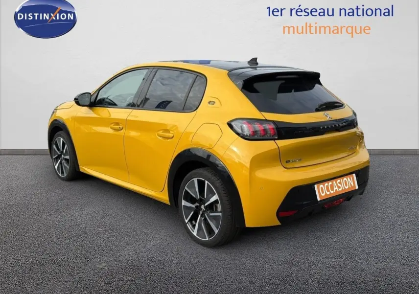 Vue 3/4 arrière droite d'une Peugeot 208 électrique jaune Faro avec toit noir et jantes alu bi-ton.