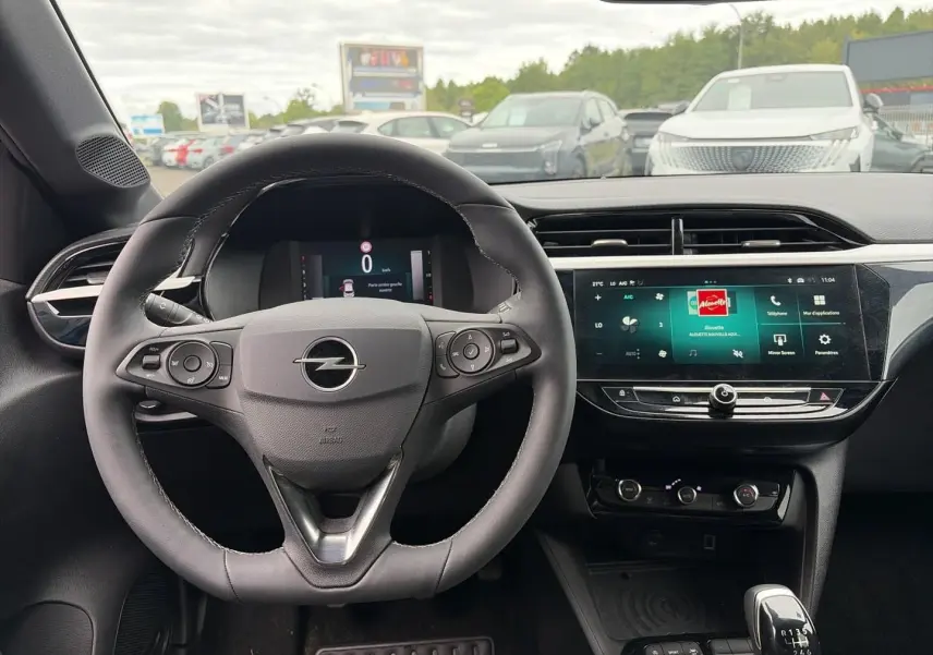 Vue intérieure centrée sur le volant sport Opel Corsa 2025 avec écran tactile et levier de vitesse manuel.