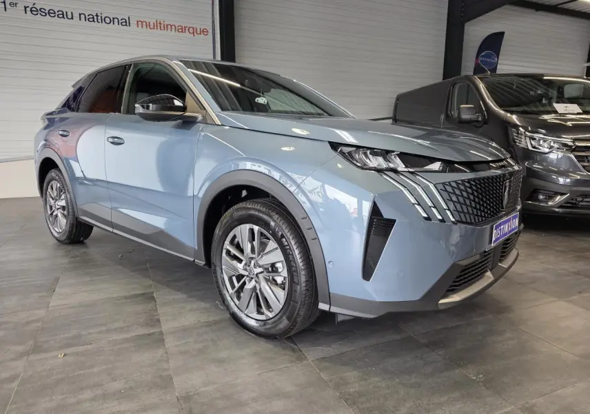 Peugeot 3008 hybride bleu vue 3/4 avant droit en intérieur, avec calandre noire laquée et jantes alliage 18 pouces.
