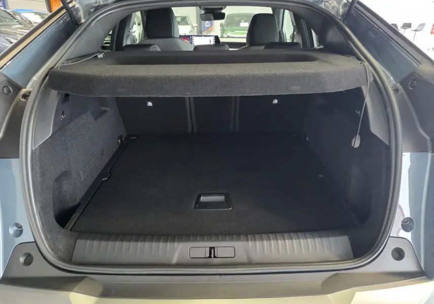 Coffre ouvert du Peugeot 3008 bleu, vue arrière montrant l’espace de chargement et la plage arrière relevée.