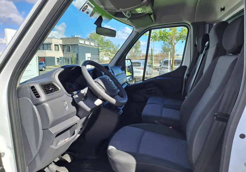 Vue intérieure côté conducteur du Nissan Interstar blanc 2024, montrant les sièges et le tableau de bord.