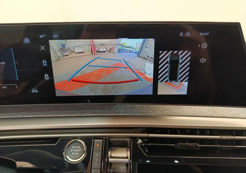 Vue rapprochée de l'écran tactile central du Peugeot 3008 blanc 2025 affichant la caméra de recul et l'aide au stationnement.