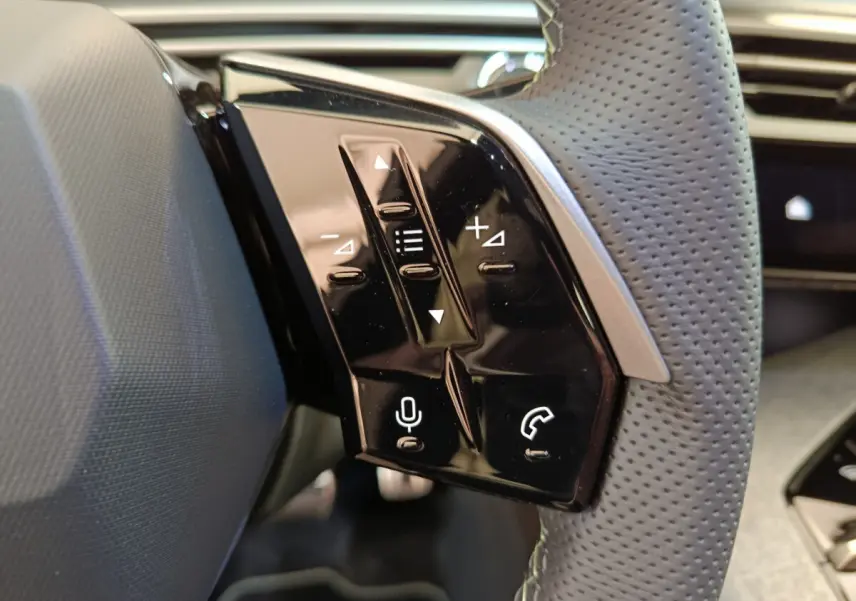 Gros plan sur les commandes vocales et téléphoniques du volant cuir perforé du Peugeot 3008 blanc 2025.