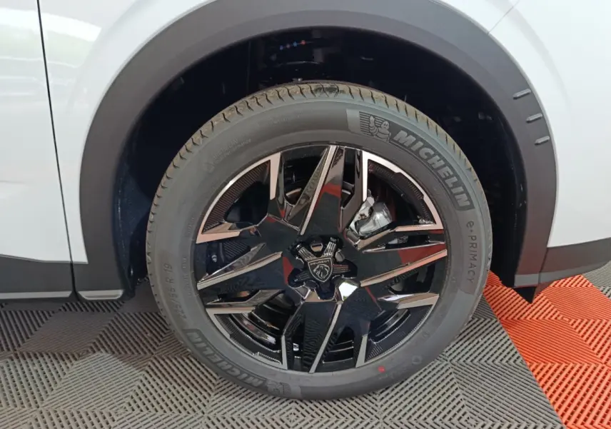 Gros plan sur la roue avant droite blanche du Peugeot 3008 1.2 HYBRID 145 GT avec jante noire brillante et pneu Michelin.