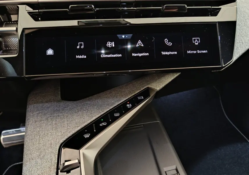 Vue rapprochée de la console centrale du Peugeot 3008 hybride 2025, avec écran tactile multifonctions et commandes climatisation.