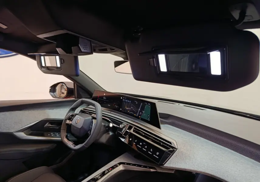 Vue intérieure côté conducteur du Peugeot 3008 1.2 Hybrid 145 GT 2025 avec tableau de bord numérique et volant cuir.