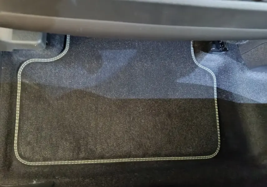 Tapis de sol noir avec surpiqûres blanches côté passager avant du Peugeot 3008 1.2 Hybrid 145 GT blanc 2025