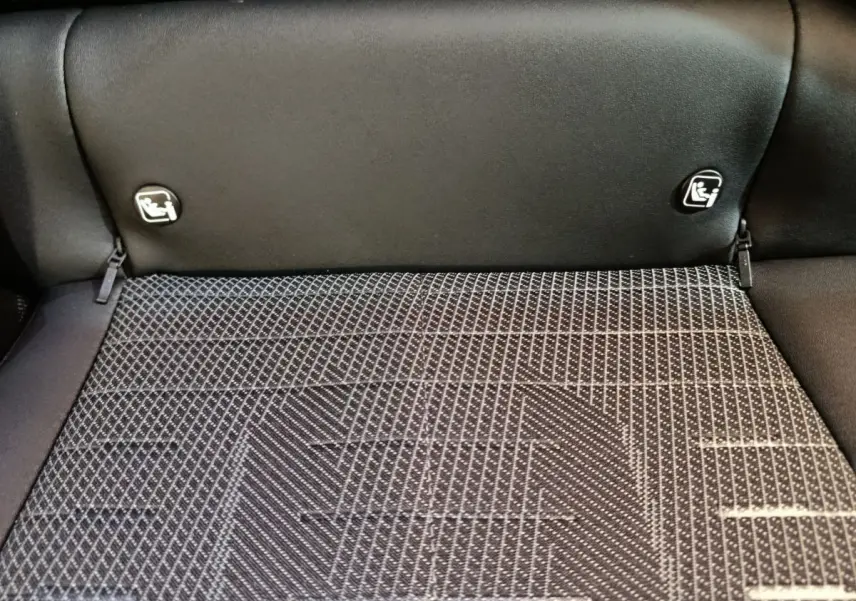 Détail du coffre du Peugeot 3008 blanc 2025 avec fixation Isofix sur la banquette arrière noire.