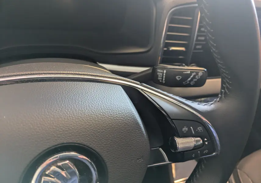 Gros plan sur la partie droite du volant noir du Skoda Karoq 2023 avec commandes de régulateur adaptatif.