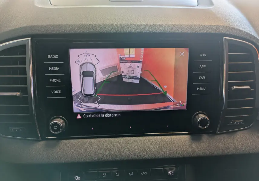 Écran central de la Skoda Karoq 1.5 TSI Business montrant la caméra de recul avec guidage de trajectoire.