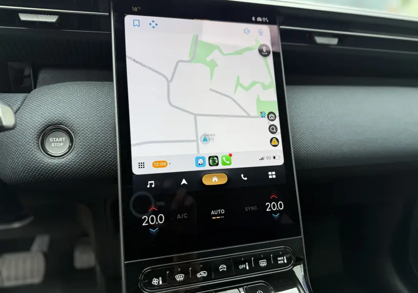 Vue rapprochée de l'écran tactile central et du bouton start/stop du tableau de bord d'une Citroën C5 Aircross hybride 2026.
