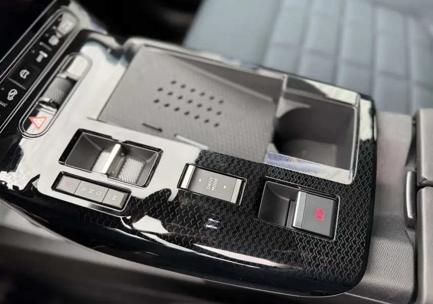 Gros plan sur la console centrale noire brillante du Citroën C5 Aircross II Hybrid avec commandes de boîte auto et frein à main électronique.