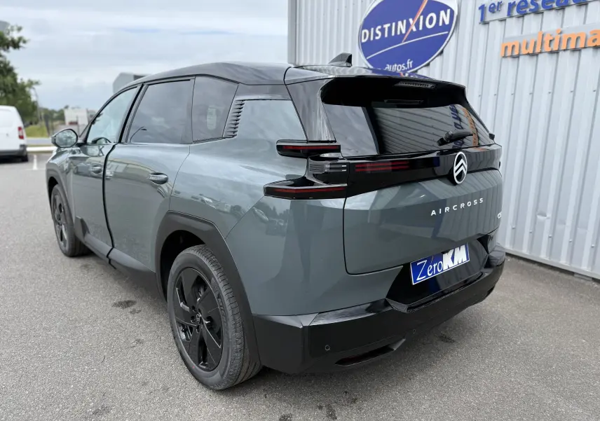 Vue 3/4 arrière droite du Citroën C5 Aircross hybride 2026 vert Astoria avec toit noir et jantes noires.