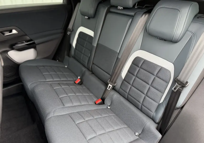 Vue intérieure en léger angle arrière droit des sièges arrière gris anthracite avec surpiqûres et ceintures de sécurité du Citroën C5 Aircross II Hybrid.