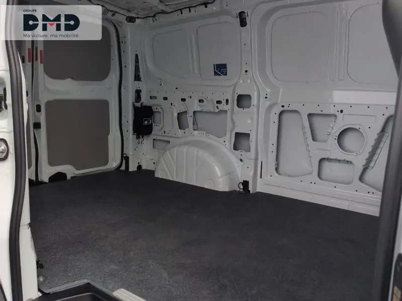 Intérieur vide du fourgon Ford Transit Custom blanc, vue côté droit avec cloison et plancher gris.