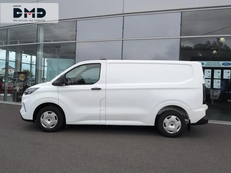 Profil latéral gauche d'un Ford Transit Custom Fourgon blanc glacier 2024 avec porte latérale coulissante et enjoliveurs simples.