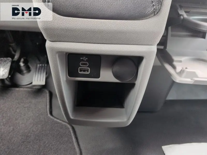 Gros plan sur la console centrale grise du Ford Transit Custom 2024 avec ports USB et prise 12V visibles.