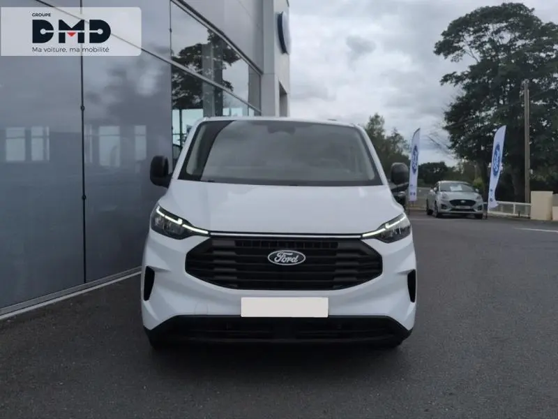 Vue de face du Ford Transit Custom Fourgon blanc Glacier avec calandre noire et phares LED allumés.