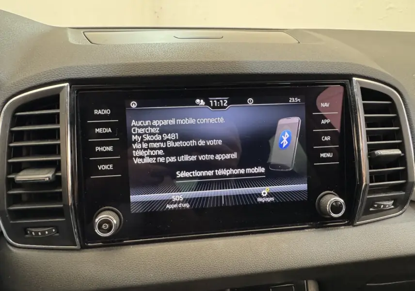 Écran tactile central du tableau de bord du Skoda Karoq blanc 2024 affichant la connexion Bluetooth.