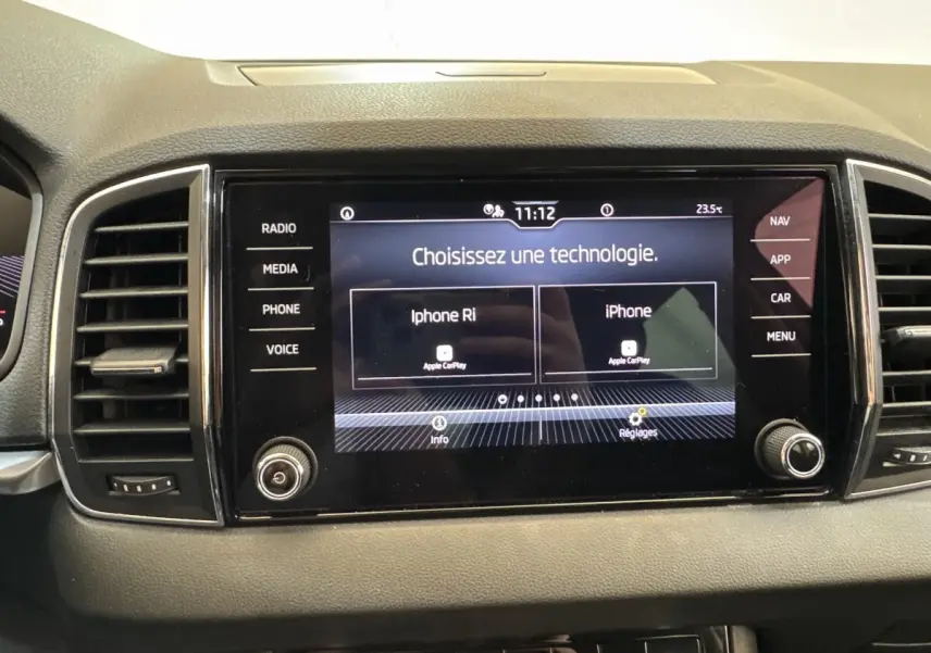 Écran tactile central du tableau de bord du Skoda Karoq blanc 2024 affichant le menu Apple CarPlay.