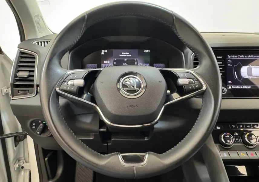 Vue rapprochée du volant cuir noir du Skoda Karoq 2024 avec tableau de bord digital et écran tactile central.