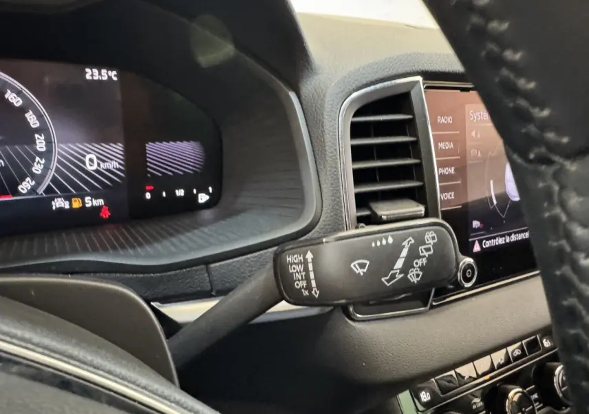 Vue intérieure du combiné d'instruments et du commodo d'essuie-glace d'un Skoda Karoq blanc 2024.