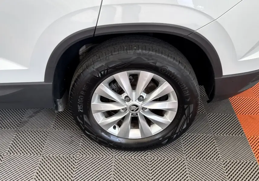 Gros plan sur la roue arrière droite d’un Skoda Karoq blanc 2024 avec jante alliage et pneu Continental.