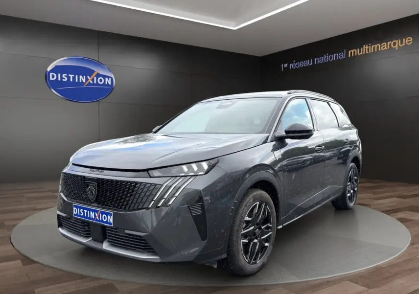 Peugeot 5008 gris foncé en 3/4 avant droit, avec calandre noire et jantes alliage noires brillantes.