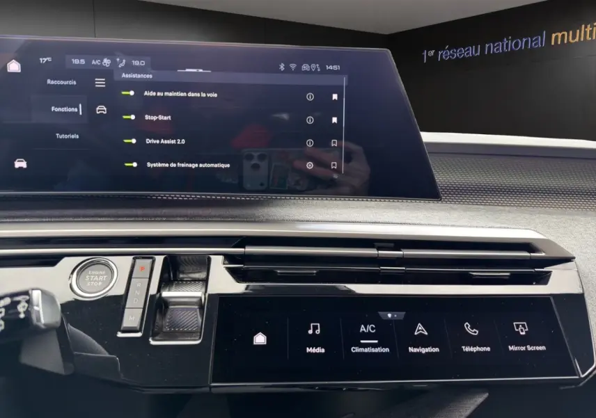Vue intérieure du tableau de bord du Peugeot 5008 gris foncé, avec écran tactile multifonctions et commandes modernes.