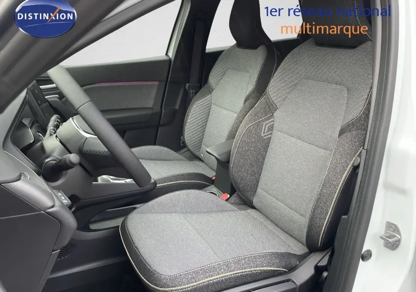 Vue intérieure côté conducteur du Renault Captur E-Tech hybride 2025, sièges tissu gris avec surpiqûres jaunes.