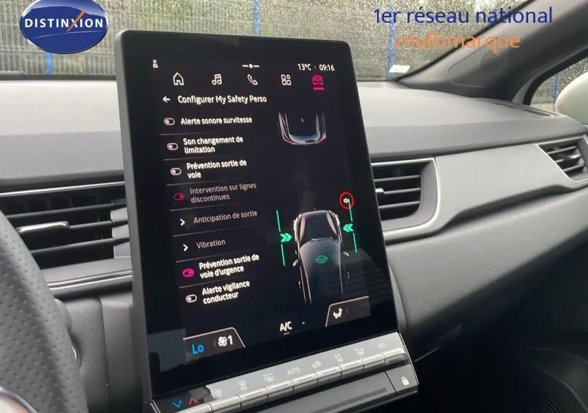 Écran tactile central affichant les aides à la conduite dans l’habitacle gris du Renault Captur blanc nacré toit beige.