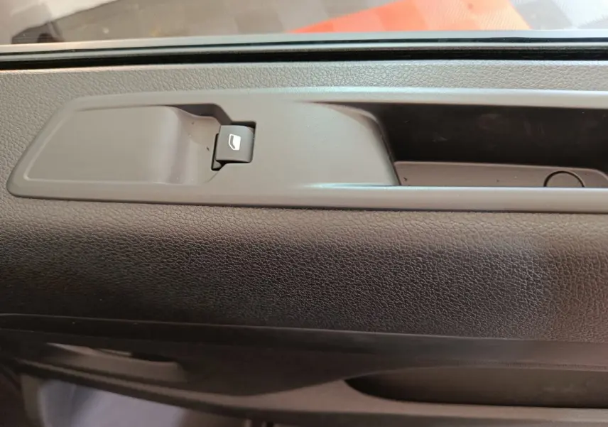 Gros plan sur la commande de lève-vitre intégrée à la porte intérieure noire du Citroën Jumpy XL 2025.