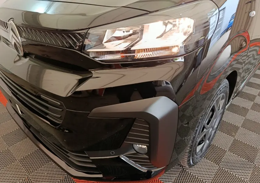 Gros plan sur l'avant droit noir brillant du Citroën Jumpy XL 2025 avec phare allumé et calandre distinctive.