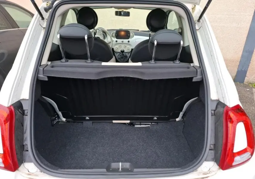 Vue arrière ouverte sur le coffre d'une Fiat 500 blanche Bossa Nova, montrant l'intérieur et le tableau de bord compact.